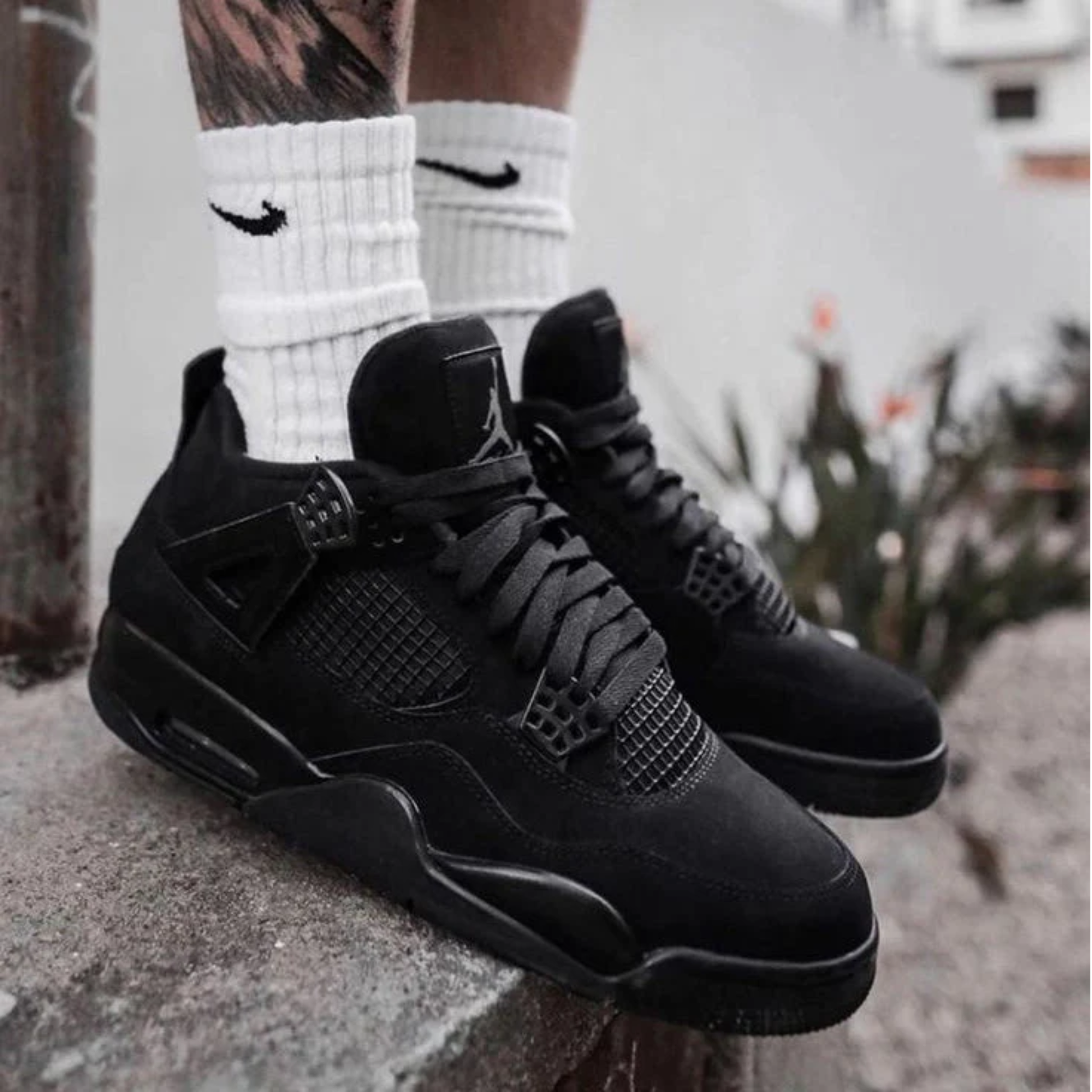 Air Jordan 4 Retro Black Cat 2025 sneakers in black worn by model