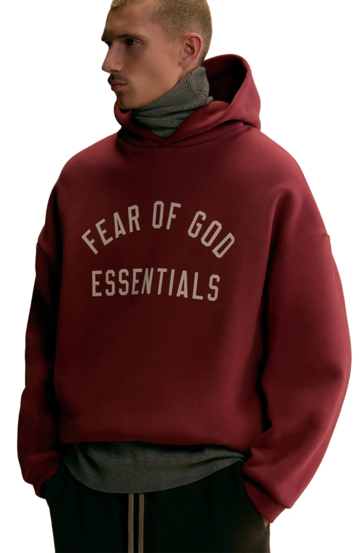 Fear Of God Essentials hoodie in crimson worn by model