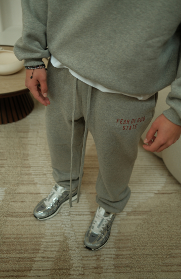 Fear of God Essentials FW24 Dark Heather State Full Set sweatpants in dark heather worn by model detail view