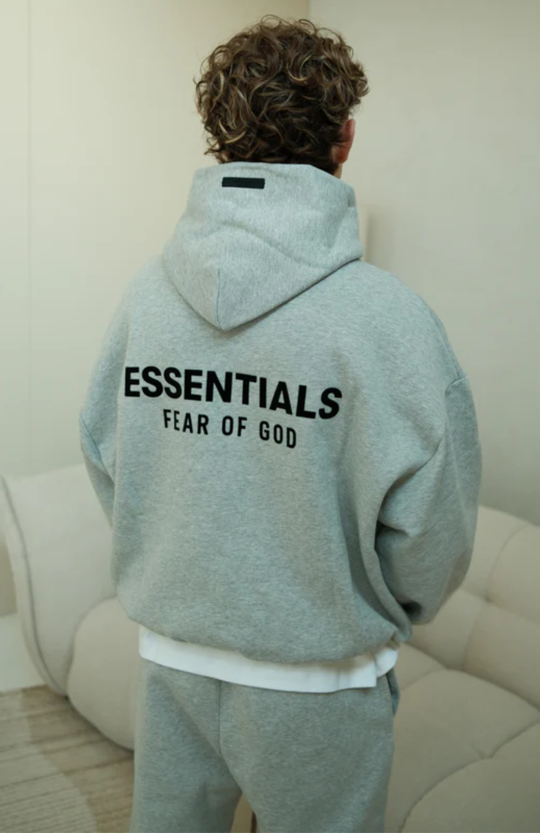 Fear of God Essentials FW24 Light Heather Full Set hoodie in light heather back view worn by model