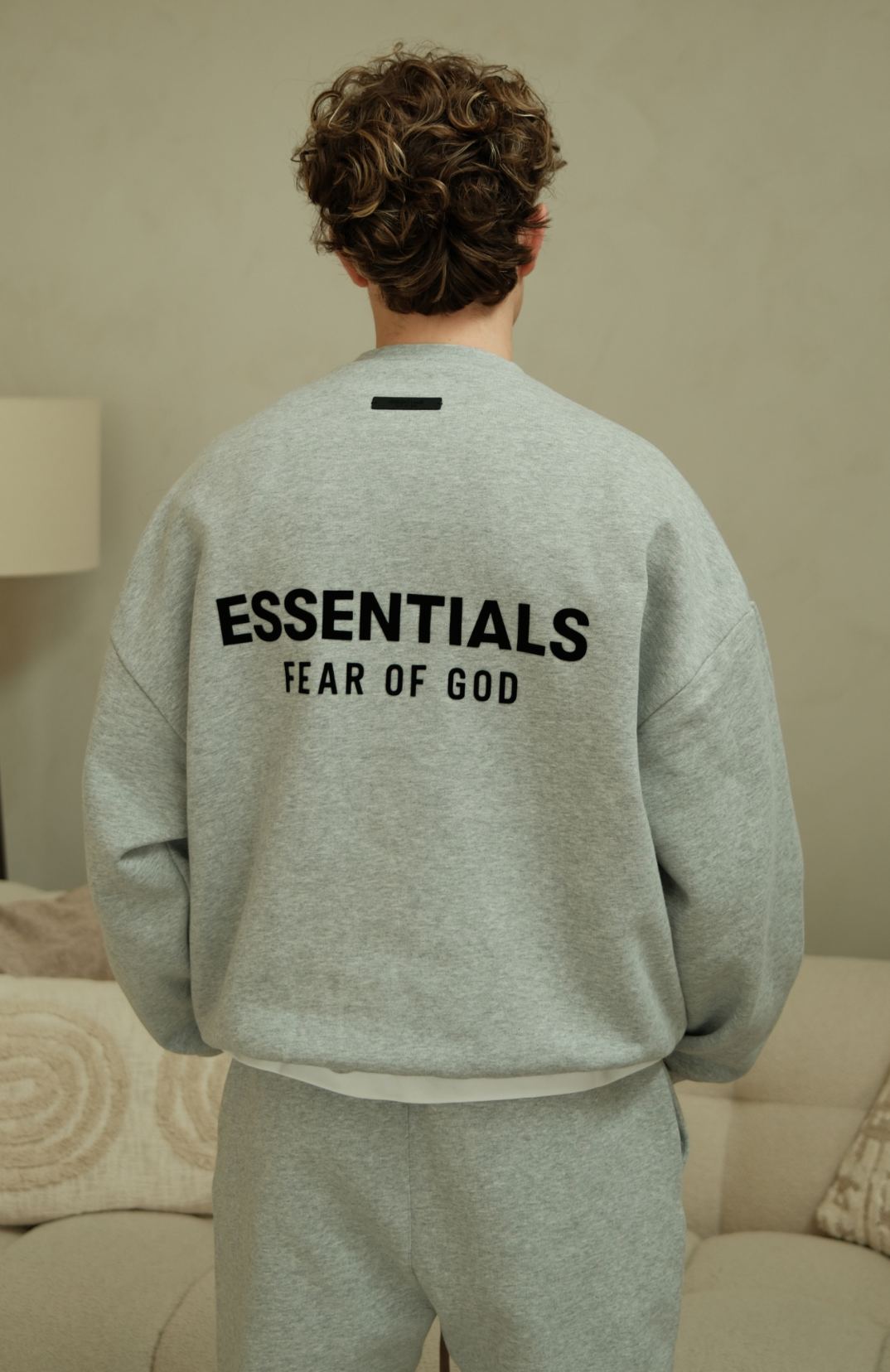 Fear of God Essentials mens fleece crewneck in heather grey worn by model back view