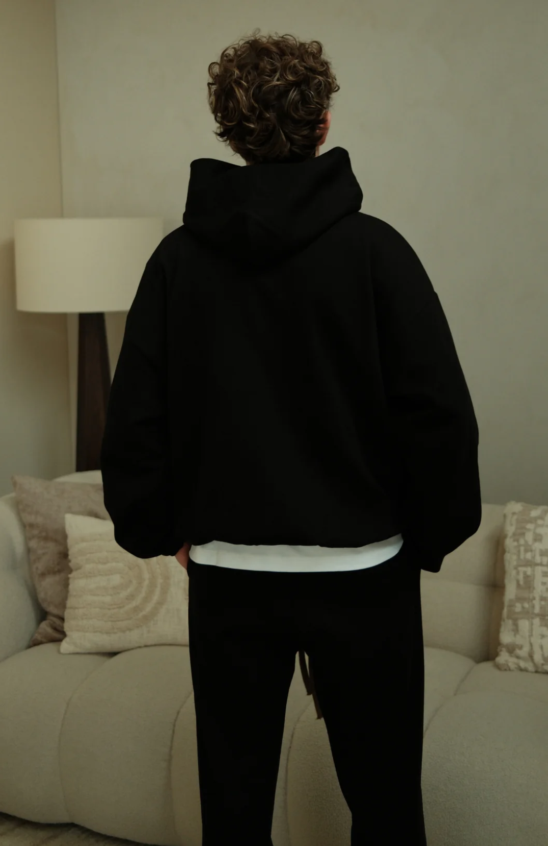 Fear Of God Essentials NBA hoodie and sweatpants set in black worn by model back view
