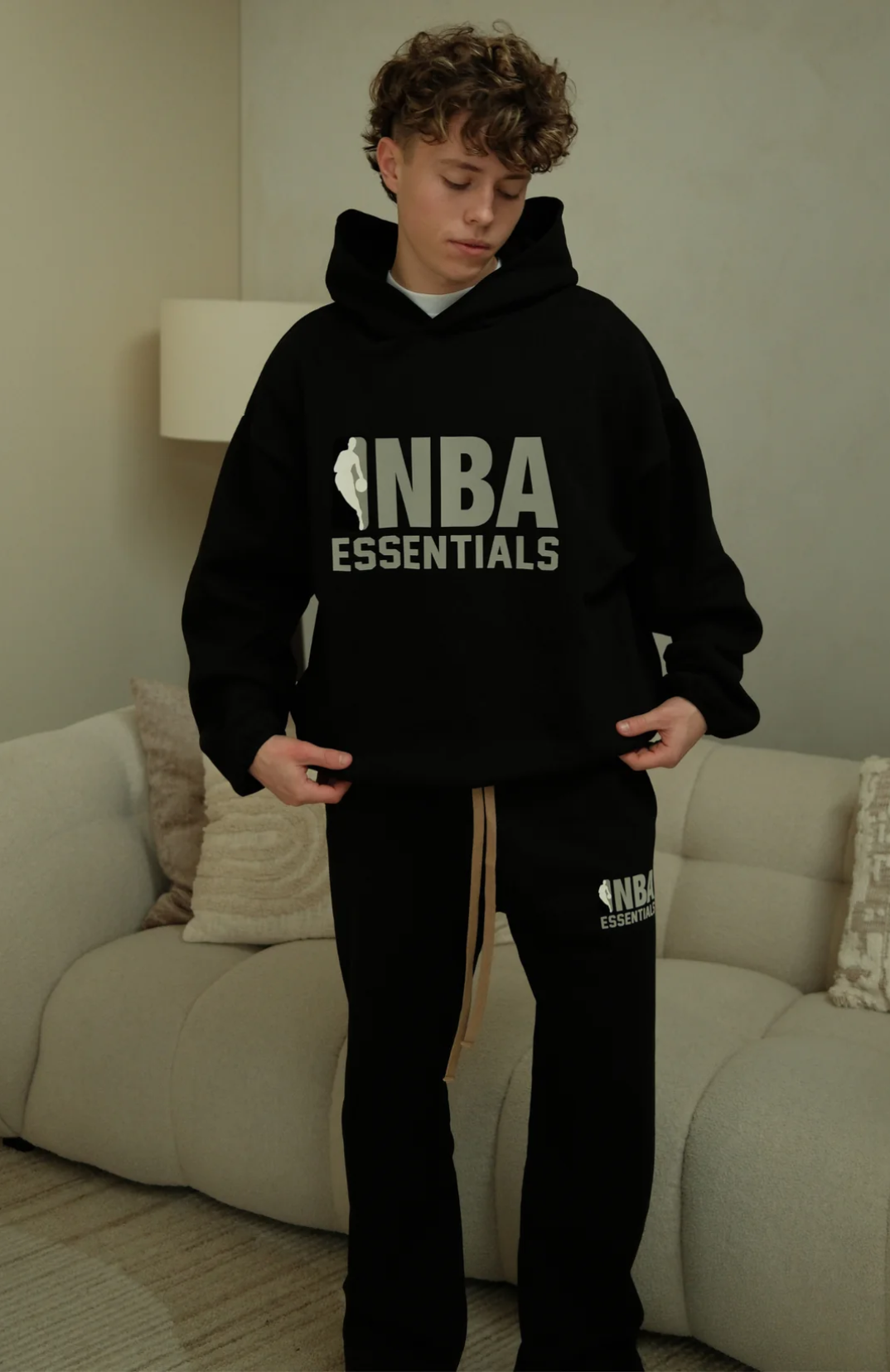 Fear Of God Essentials NBA hoodie and sweatpants set in black worn by model detail view