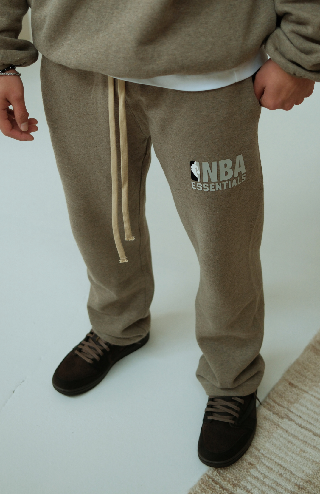 Fear of God Essentials NBA Warm Heather Broek sweatpants in warm heather worn by model